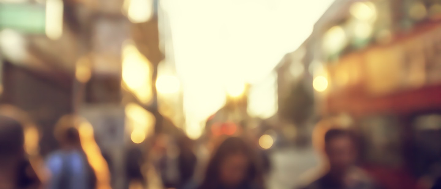 A crowded street at golden hour, everyone out of focus.